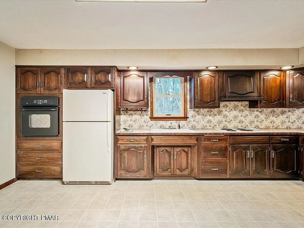 Original dark wood kitchen cabinetry and appliances in the Dallas, PA home