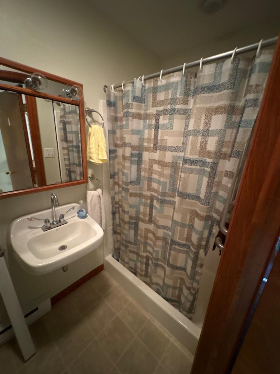 Dallas PA bathroom before — original fixtures, wood-trim mirror, functional but dated