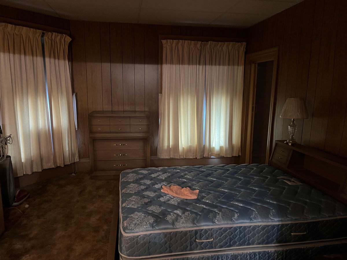 Erie PA master bedroom — dark wood paneling, full set of original furnishings, heavy curtains