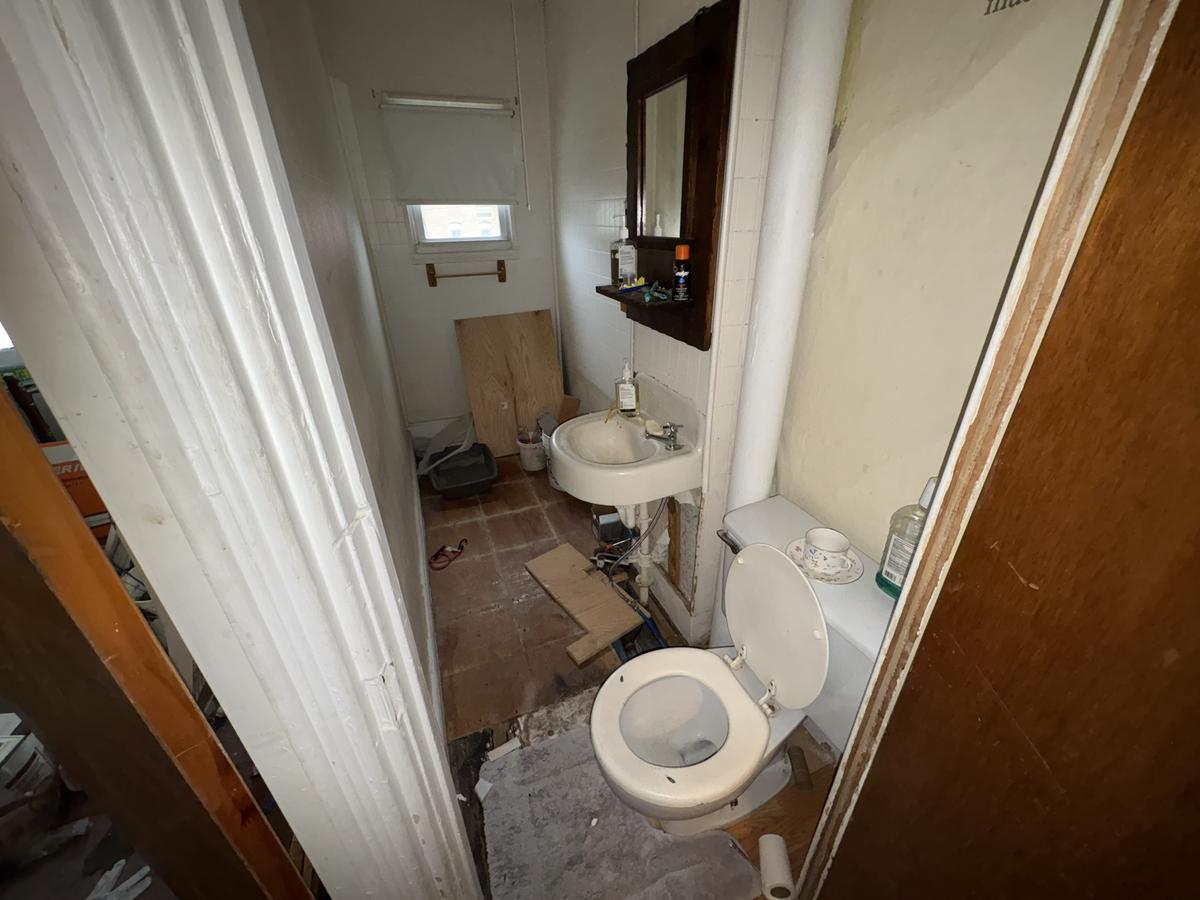 Wilkes-Barre unit bathroom before — original fixtures, debris, disrepair