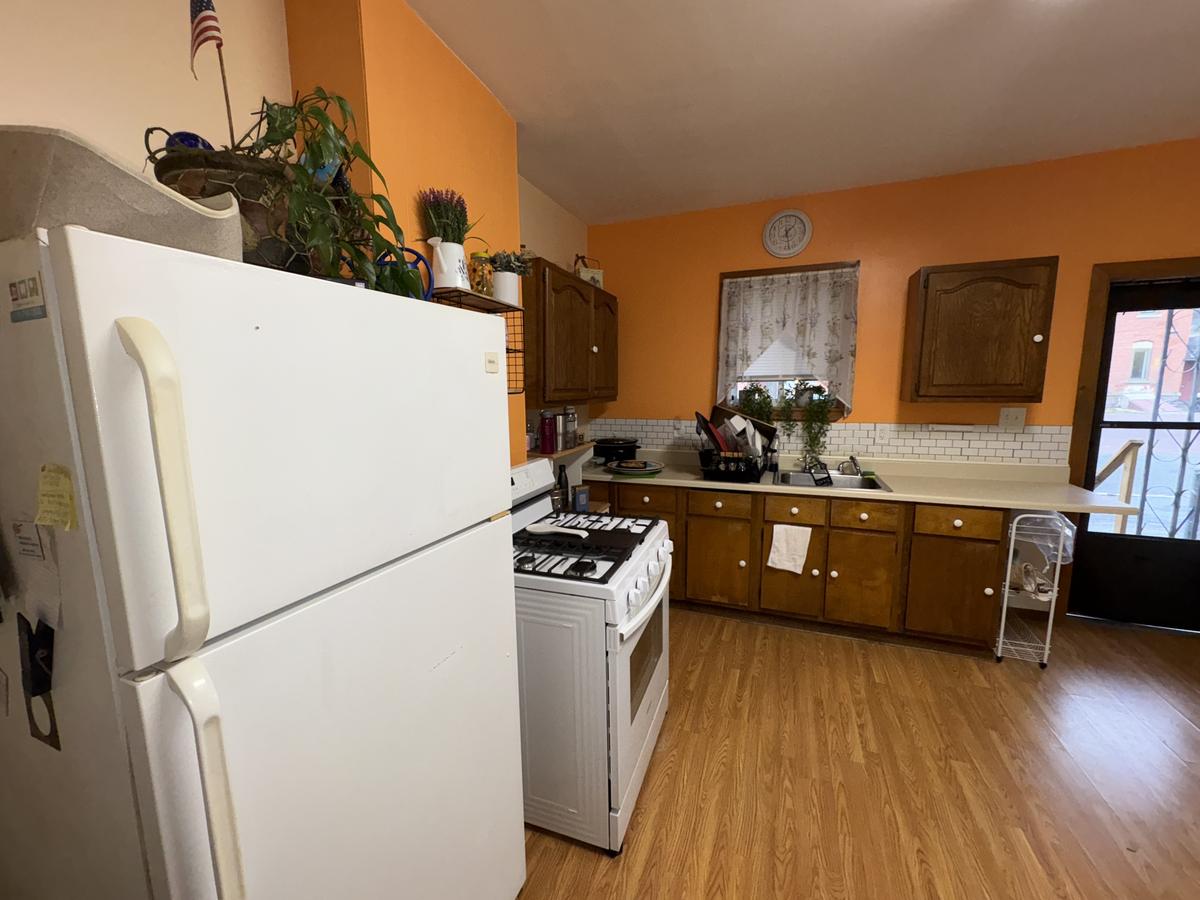 Wilkes-Barre unit kitchen before — orange walls, wood cabinets, occupied