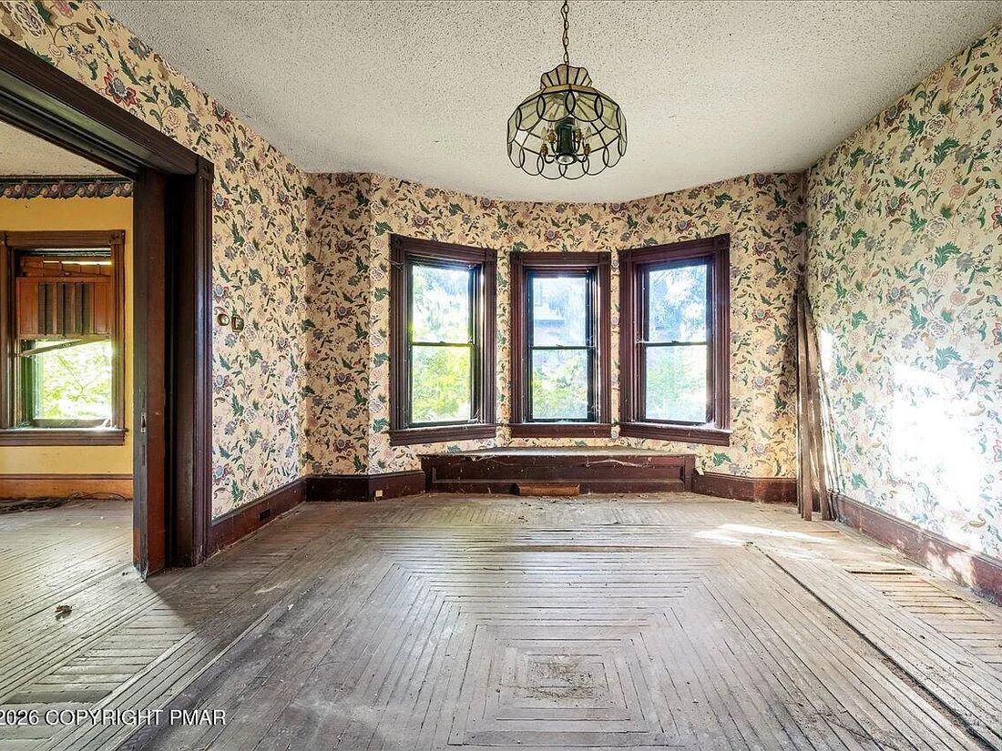 Bay window and original wallpaper in the Williamsport Victorian's front room