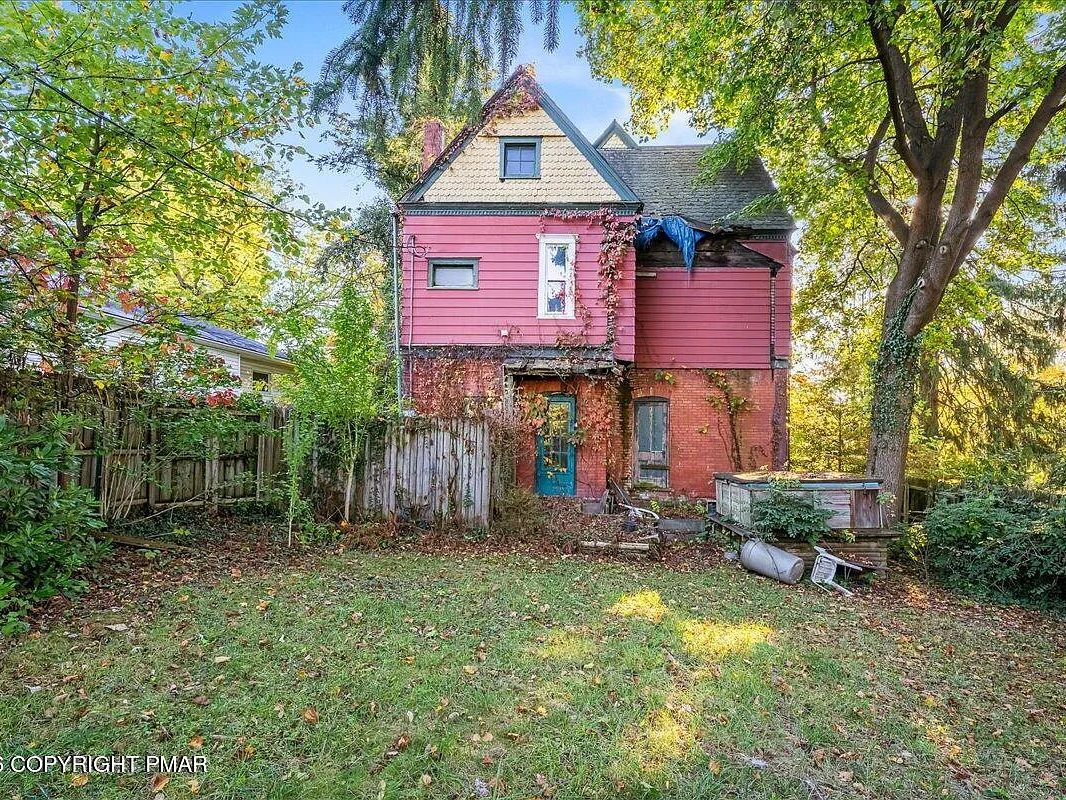 Rear elevation and overgrown yard of the Williamsport Victorian