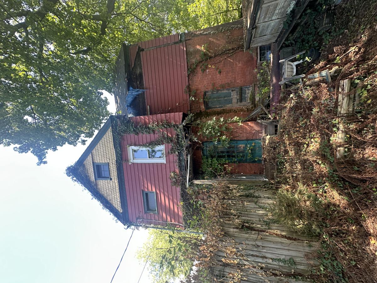 1901 Victorian before — overgrown, collapsed porch, red brick