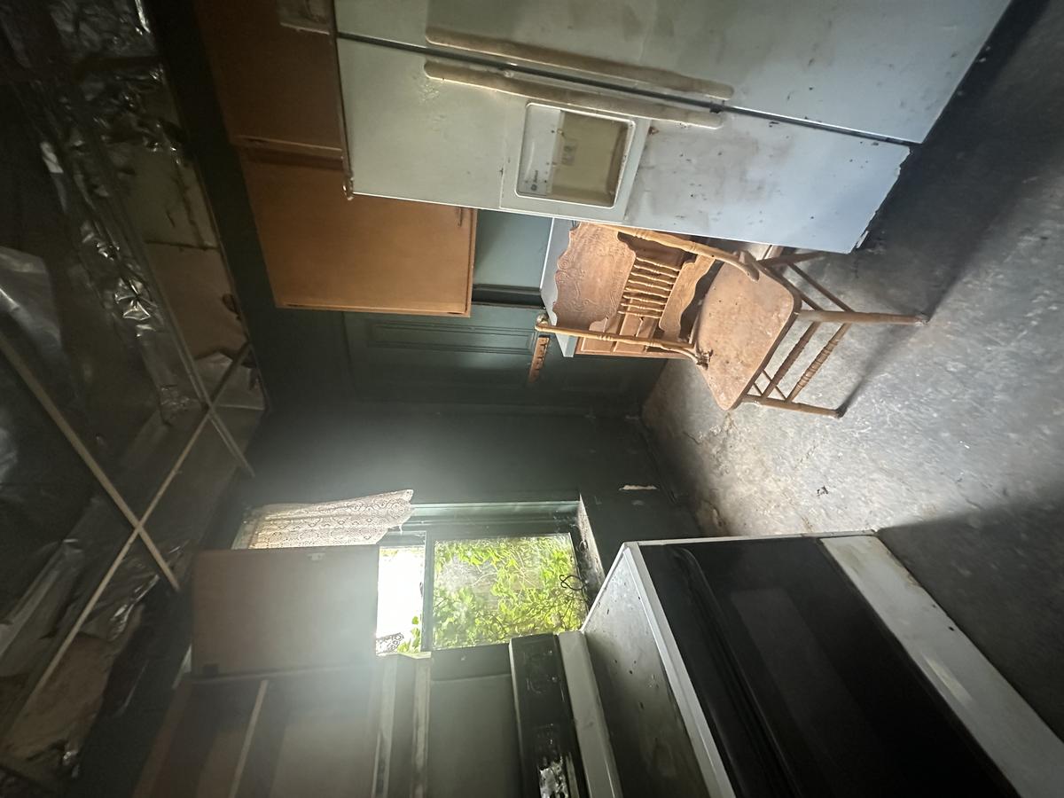 Victorian kitchen before — collapsed ceiling with plastic sheeting, original appliances, severe water intrusion