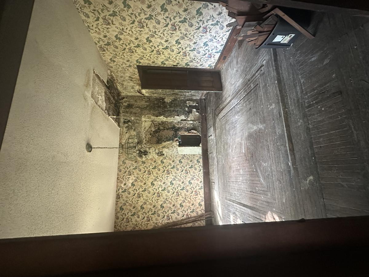 Victorian parlor before — original hardwood inlay floors, extensive black mold, ceiling collapse