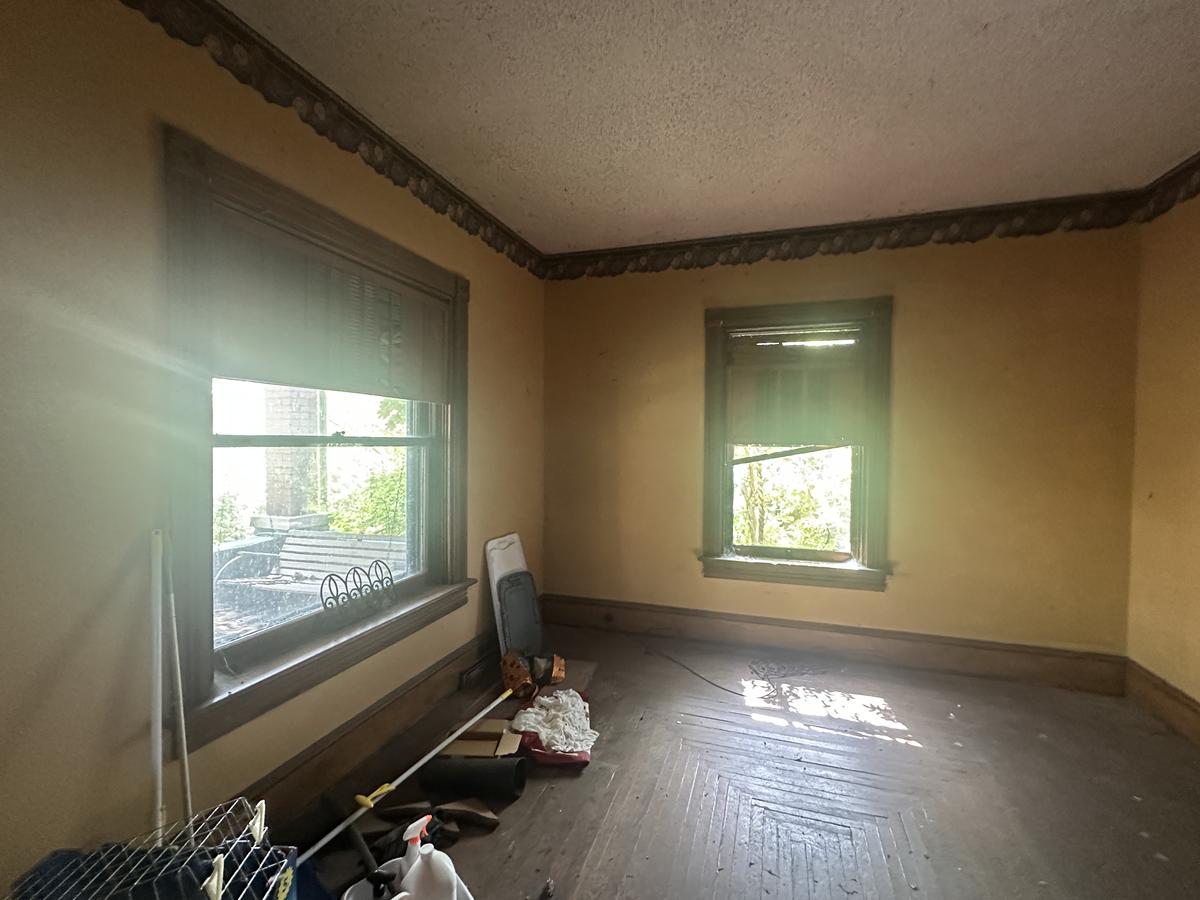 Victorian room before — ornate original crown molding, 9-foot ceilings, vacant and deteriorated